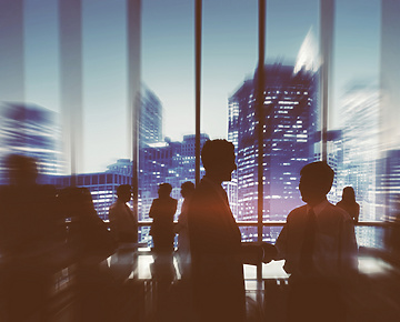 a silhouette of a person shaking hands with other people in a room with windows