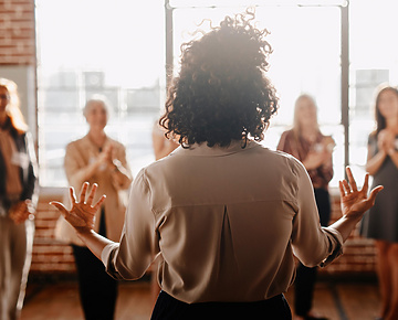 Woman giving a speech in front of a group of women.