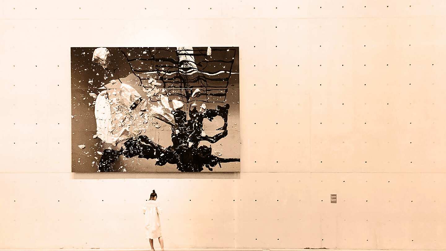Woman stood in an art gallery looking at abstract art