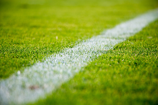 synthetic green grass and crisp white lines of a football field