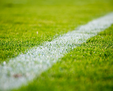 synthetic green grass and crisp white lines of a football field