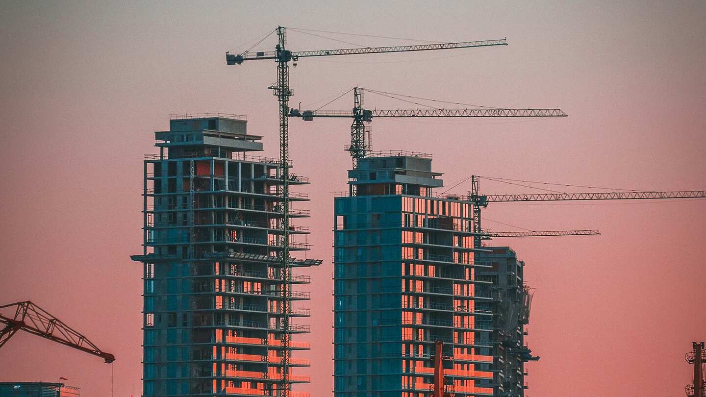 Buildings and cranes on a sunset skyline