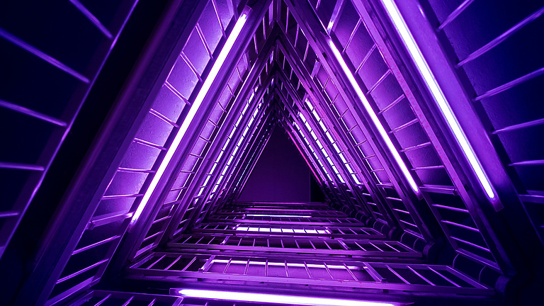 a triangle shaped staircase with purple lights