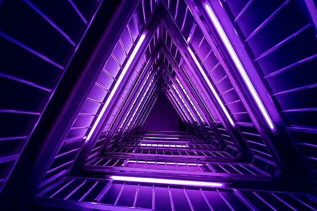 a triangle shaped staircase with purple lights