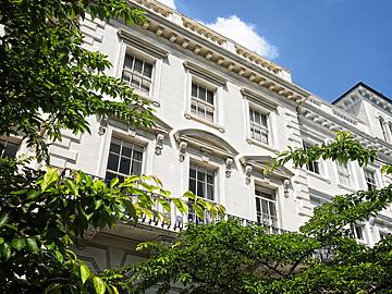 a white building with trees in the background