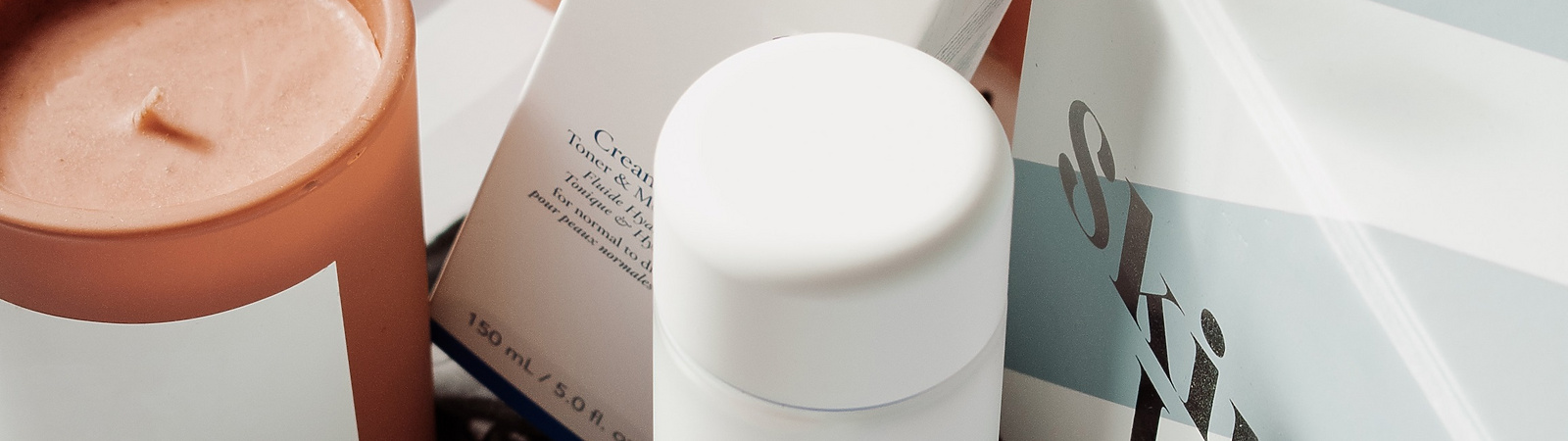 a group of white containers and a candle on a book