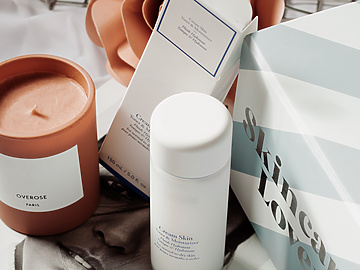 a group of white containers and a candle on a book