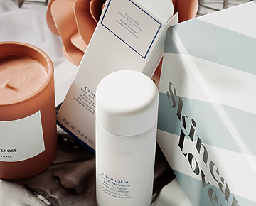 a group of white containers and a candle on a book