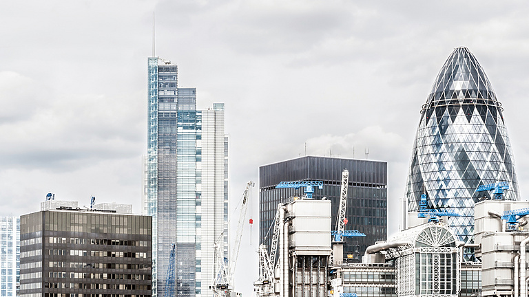 a group of tall buildings with cranes