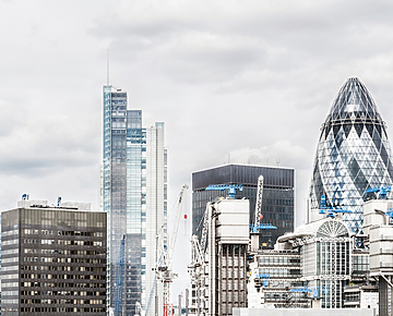 a group of tall buildings with cranes