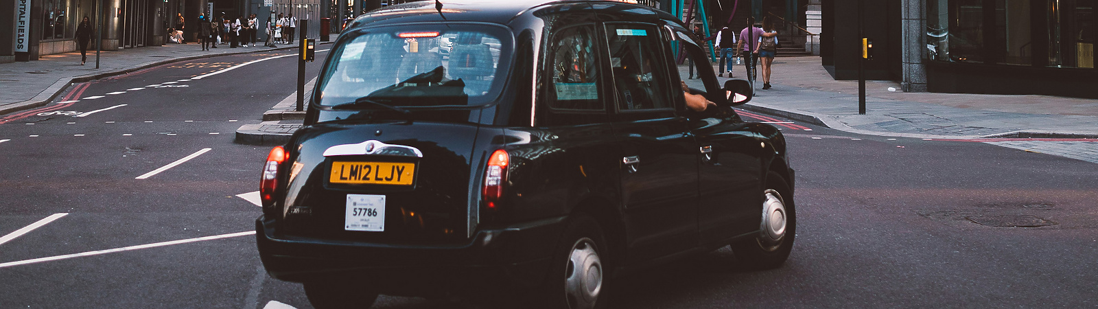 Black cab turning right with St Mary Axe in the background