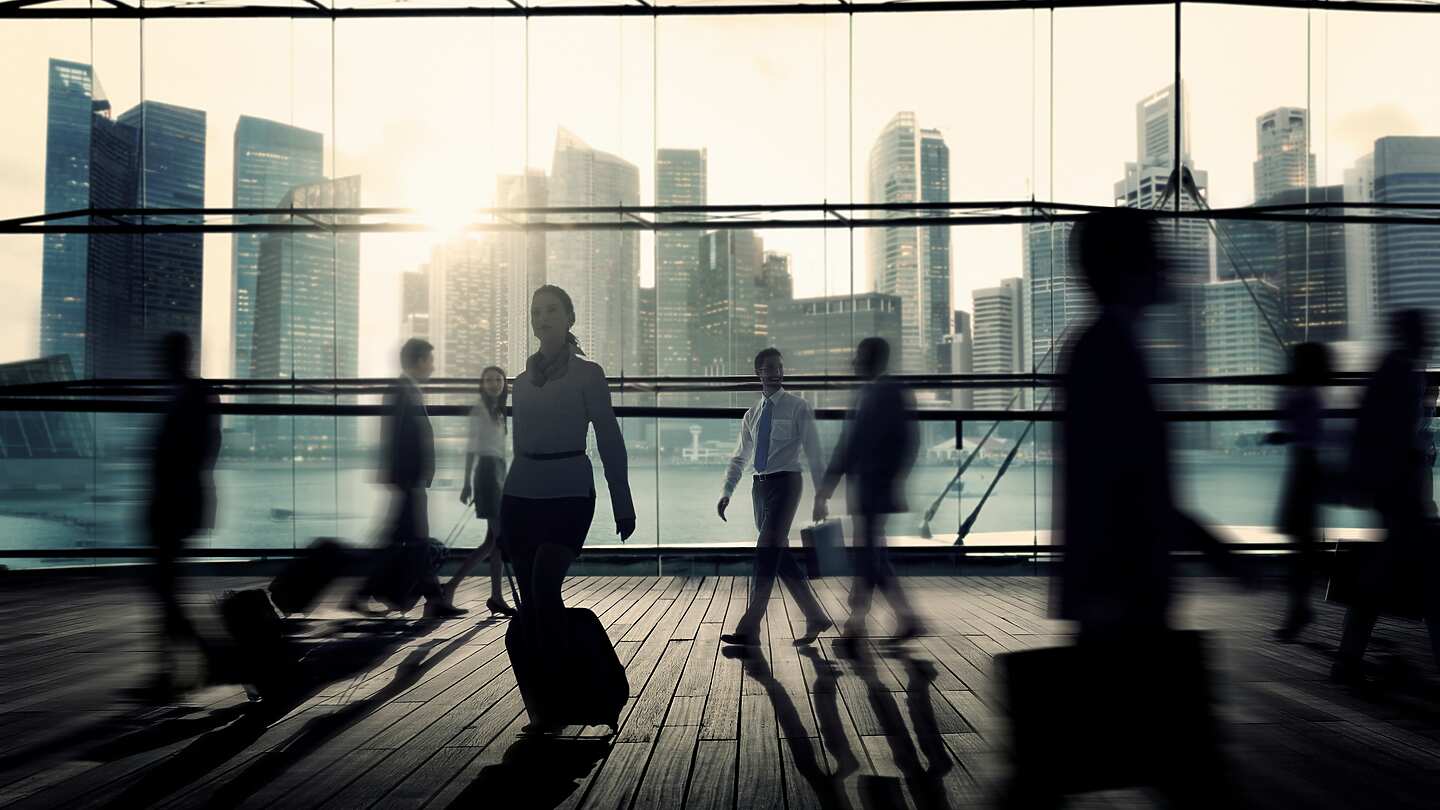 a group of people walking in a large room with windows