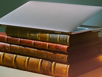 a laptop on top of a stack of books