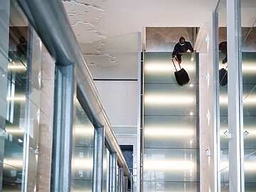 man walking in lobby with suitcase