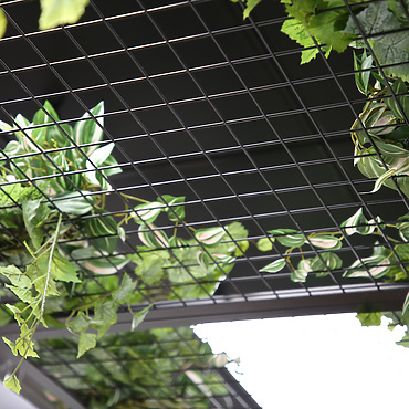 a wire mesh with green leaves