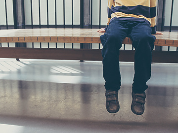 Kid sitting on a bench