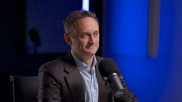 a person sitting at a table with a microphone