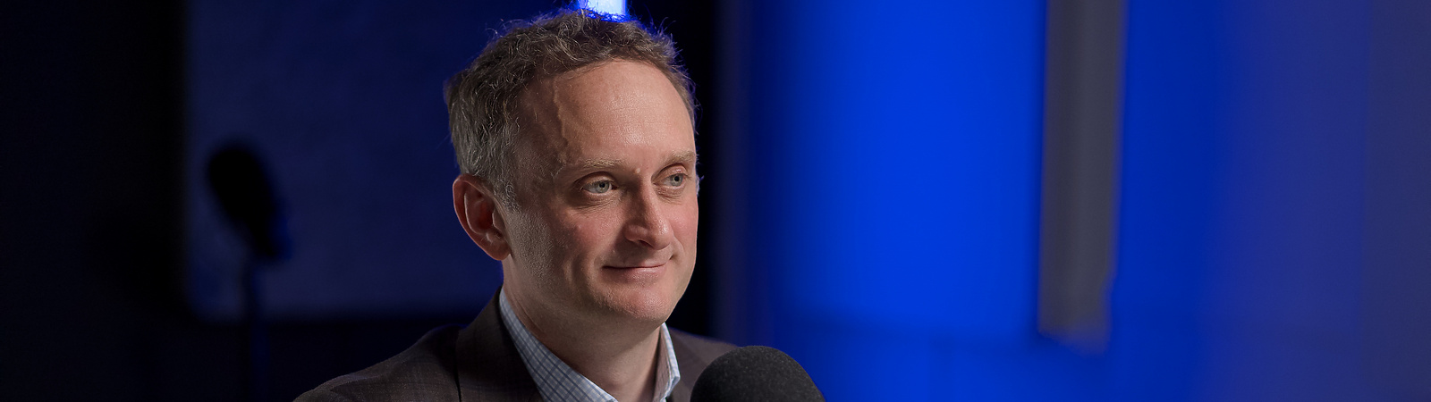 a person sitting at a table with a microphone