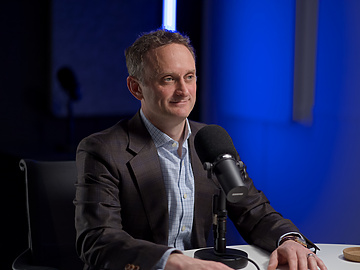 a person sitting at a table with a microphone