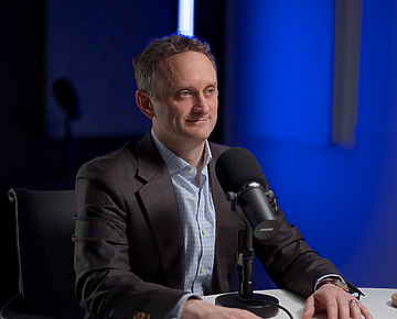 a person sitting at a table with a microphone