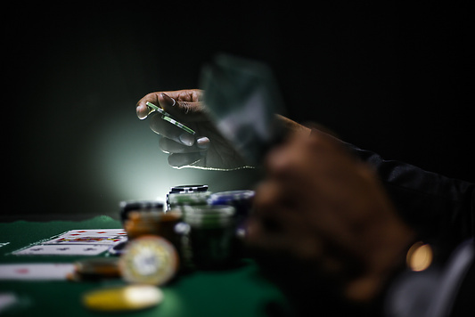a person holding playing cards at a gambling table