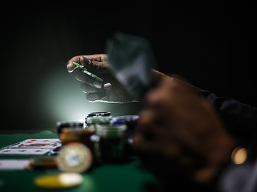 a person holding playing cards at a gambling table