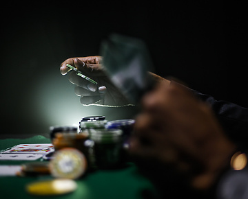 a person holding playing cards at a gambling table