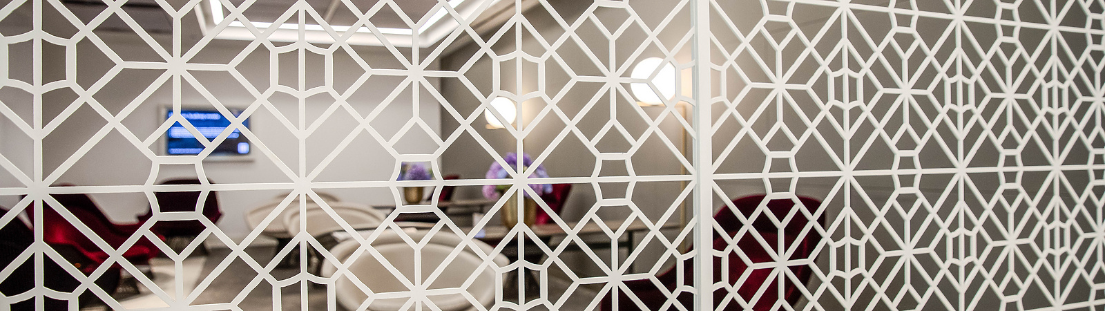 a white patterned screen with a room behind it