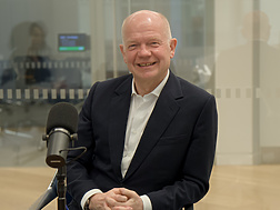a person sitting at a desk with a microphone