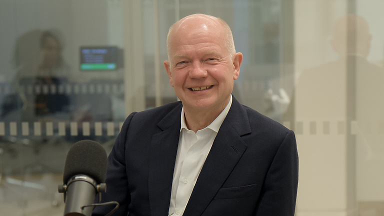 a person sitting at a desk with a microphone