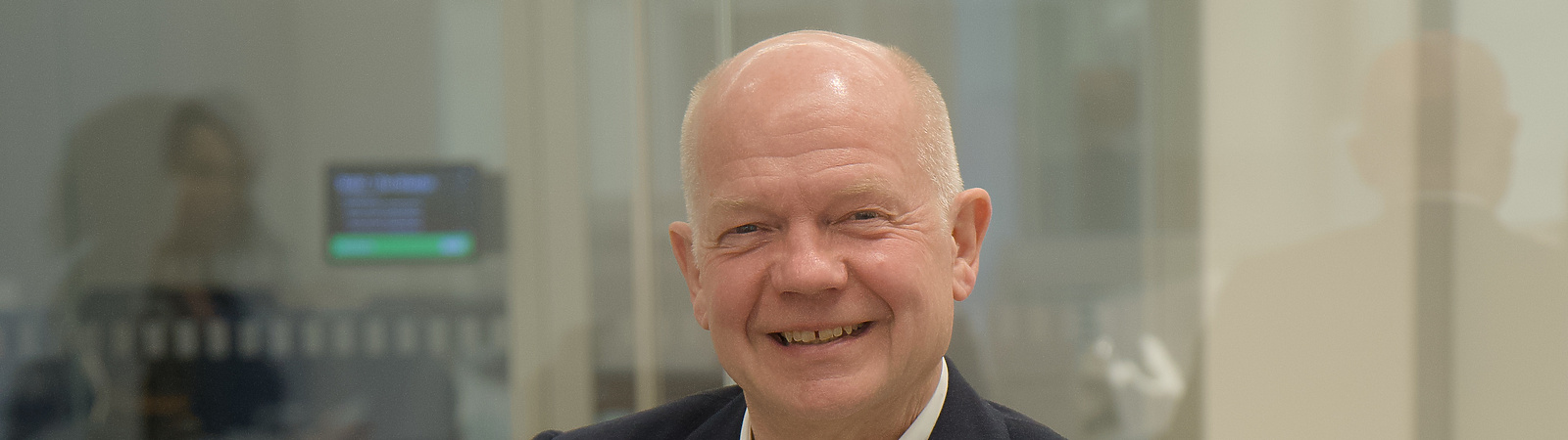 a person sitting at a desk with a microphone