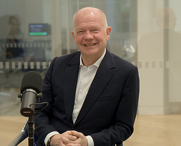 a person sitting at a desk with a microphone