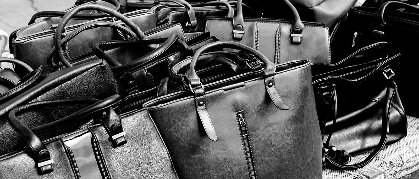 a group of black leather handbags
