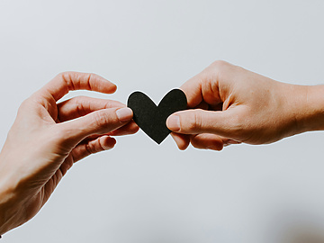 a person handing a heart to another