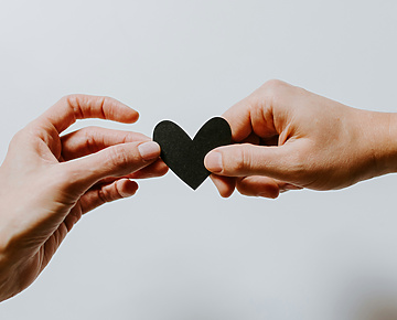 a person handing a heart to another