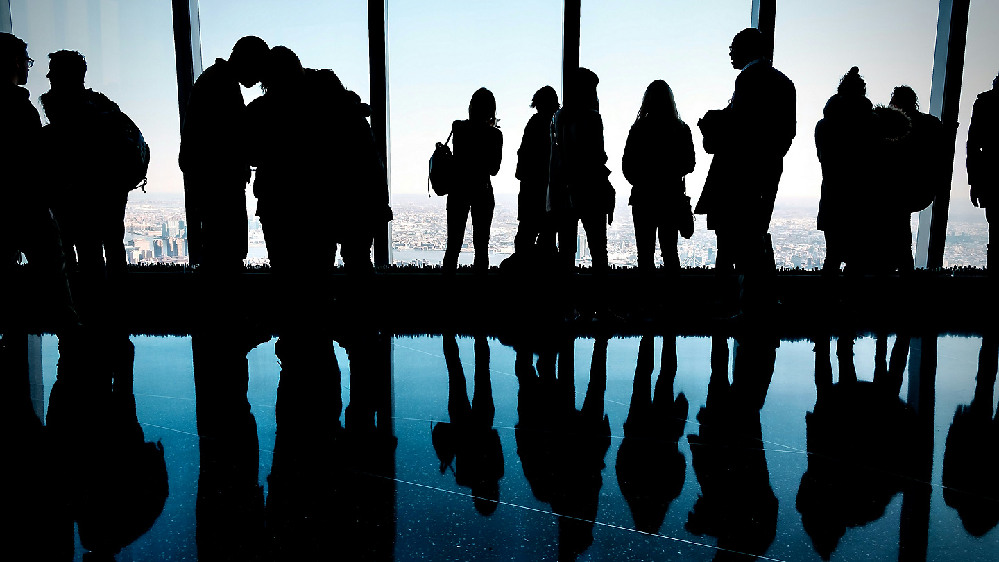 a group of people standing in front of a large window
