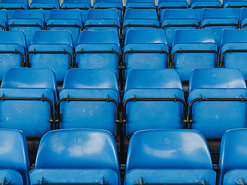 rows of blue seats in a stadium
