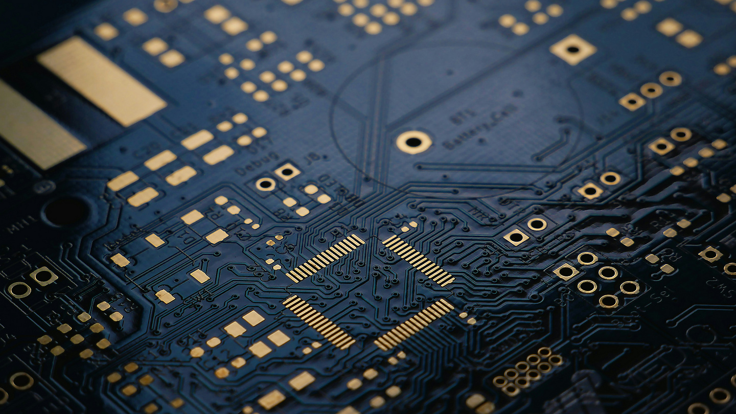 A low exposure photograph of an unsoldered Printed Circuit Board (PCB) with ENIG (Gold) finish.