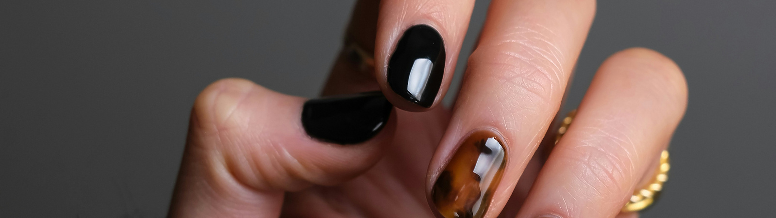 a hand with black and brown painted nails