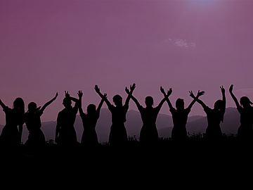 row of women holding hands up