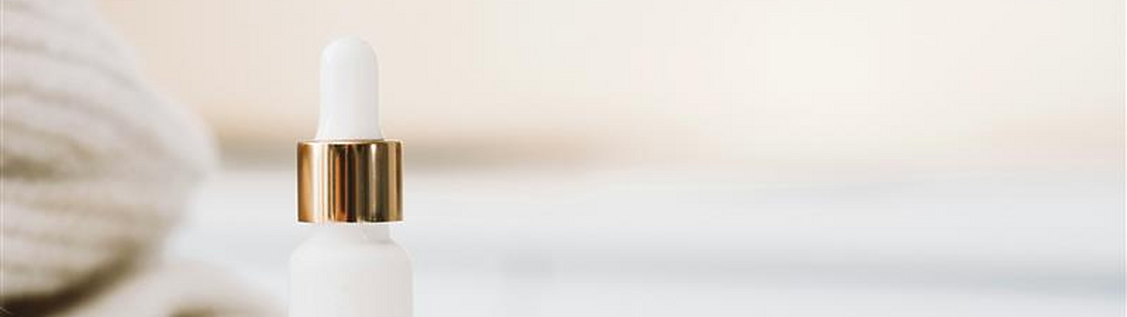 a white bottle with a gold cap