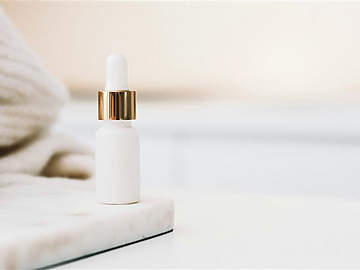 a white bottle with a gold cap