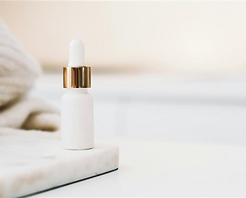 a white bottle with a gold cap