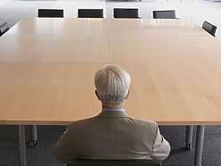A man on his own in a meeting room
