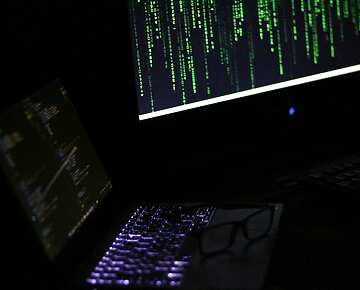Two laptops in a dark room