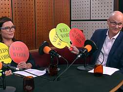 a group of people sitting at a table with microphones