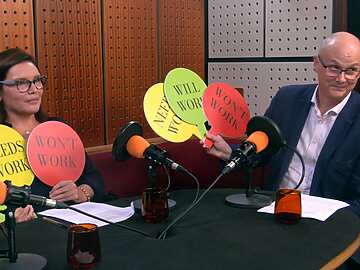 a group of people sitting at a table with microphones
