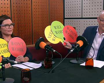 a group of people sitting at a table with microphones