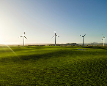 a wind turbines in a field with a Wind Farm in the background