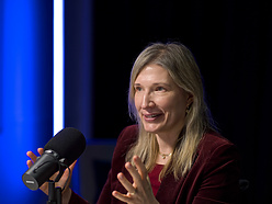 a person sitting at a desk with a microphone
